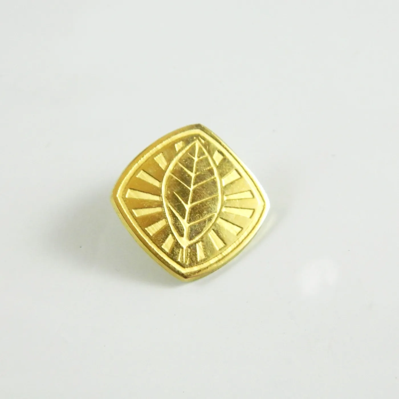 Pin dorado con relieve de hoja y acabado brillante