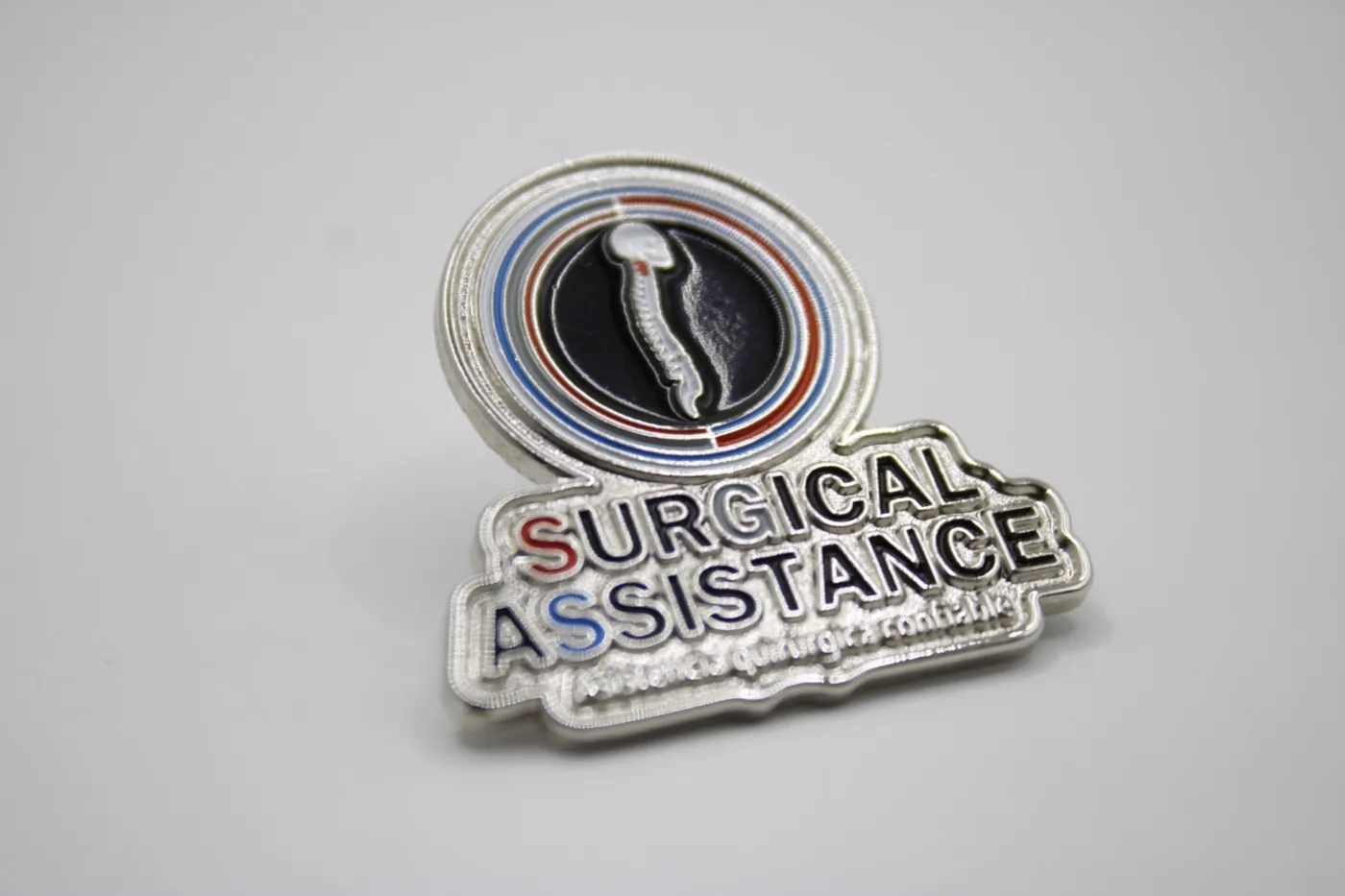Pin corporativo troquelado con logotipo de Surgical Assistance