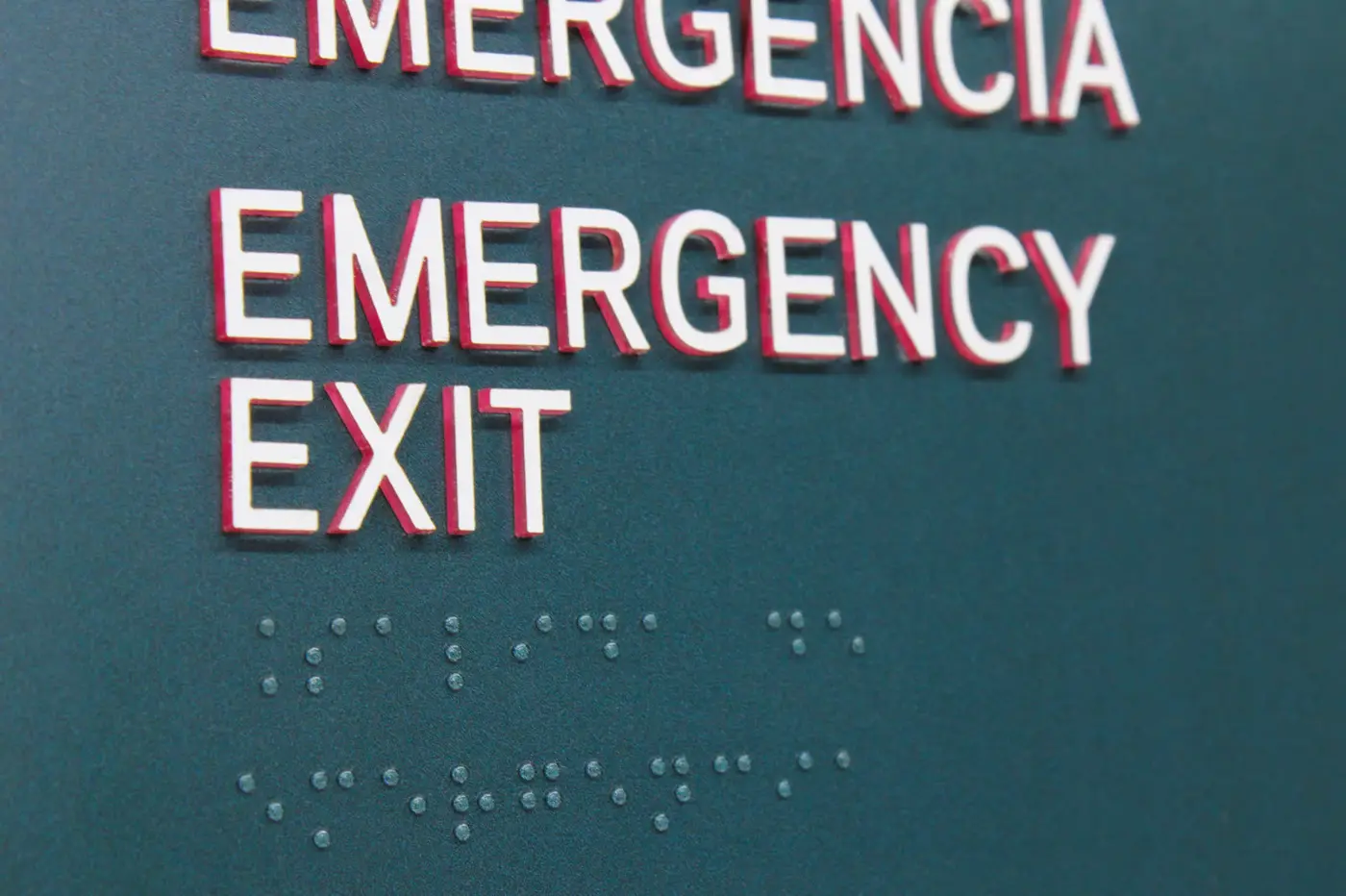 Detalle de señalética de emergencia con Braille en hotel Aloft