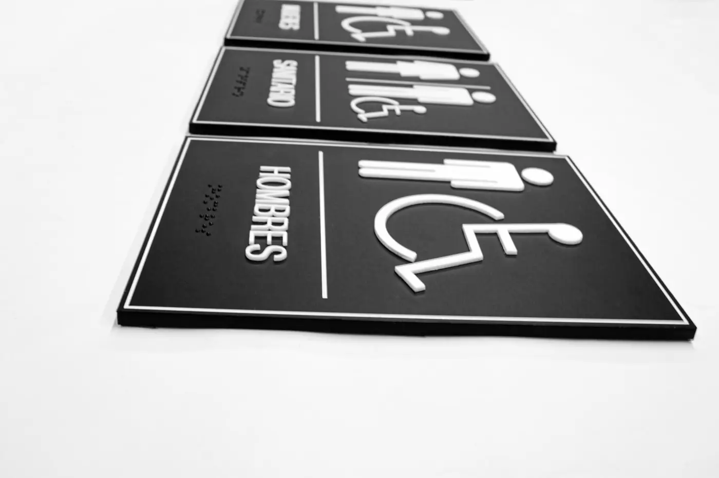 Señalética de baños con pictogramas y sistema Braille fabricada para Amazon
