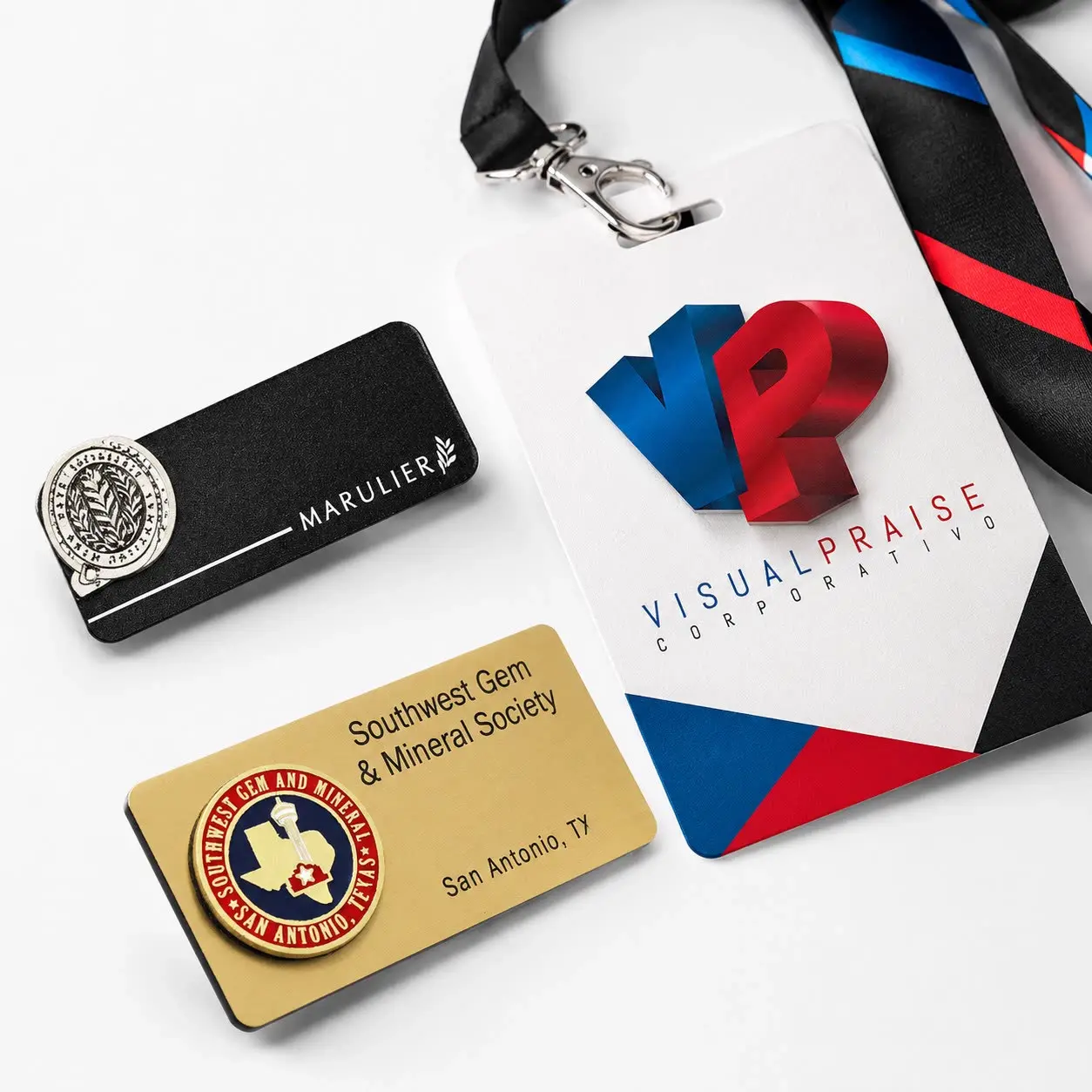 Credencial de PVC Visual Praise con cordón corporativo junto a placas de nombre metálicas